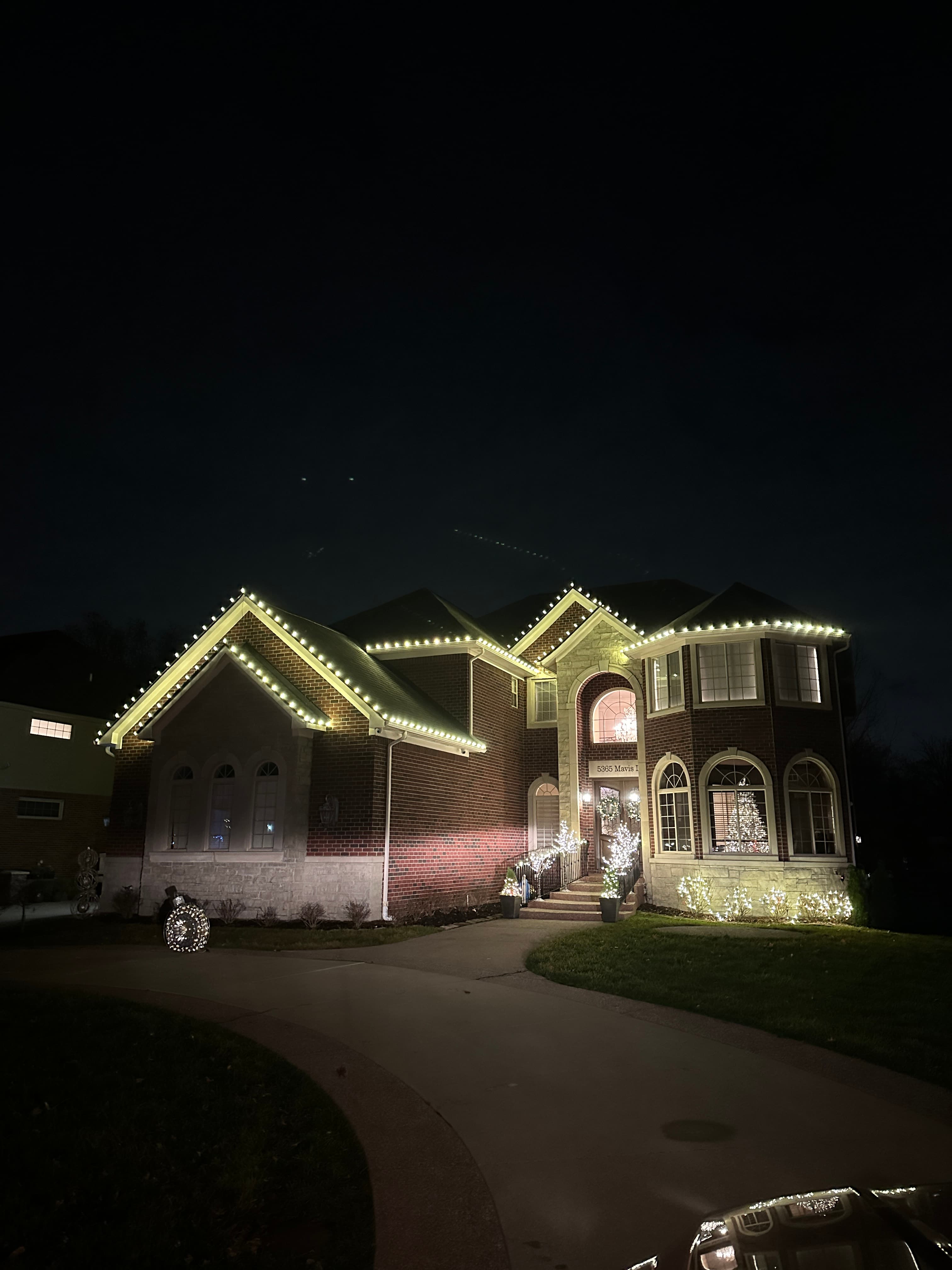 Professional installing Christmas lights on a home